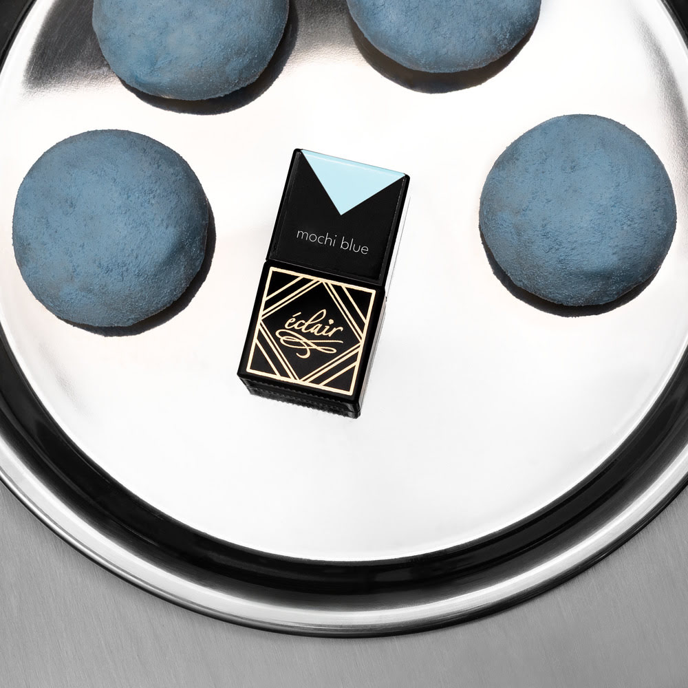 Lakier hybrydowy Mochi Blue na tle błękitnych makaroników